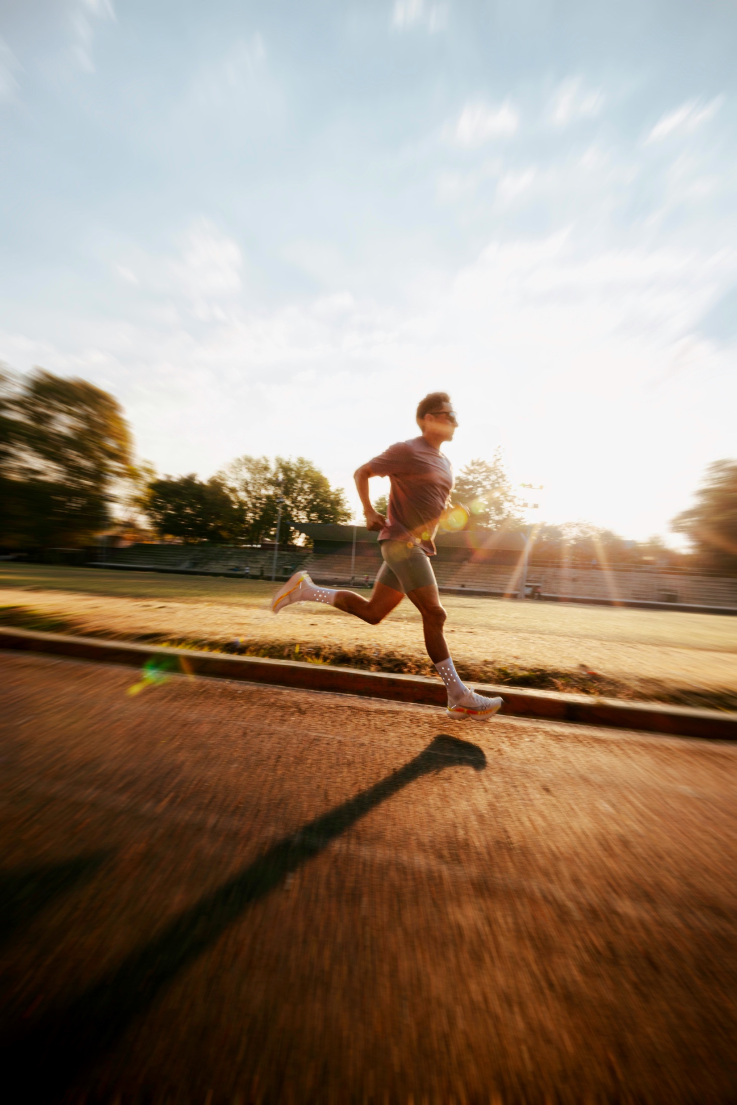 Sprinter at golden hour, sunlight flare behind