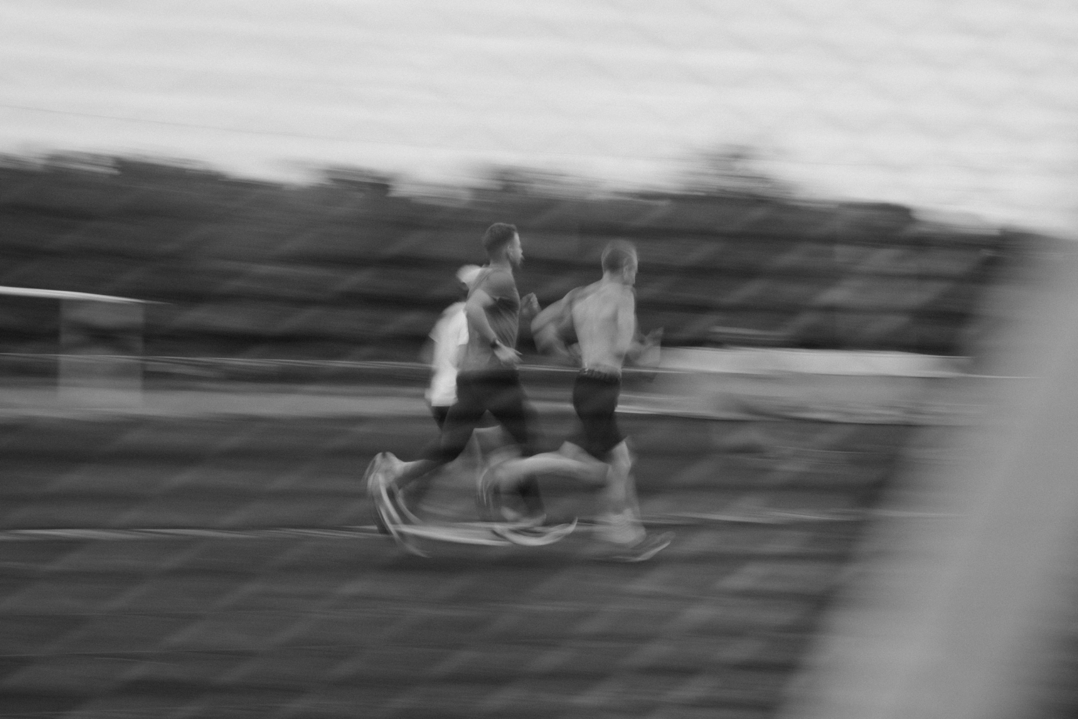 Three runners at speed, motion blur, black and white